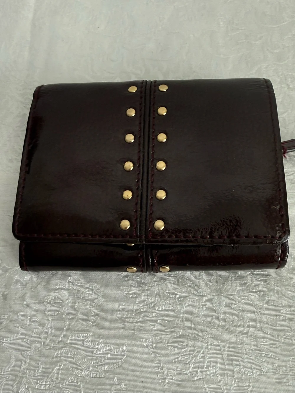 Michael Kors Burgundy patent bifold wallet with Gold Studs